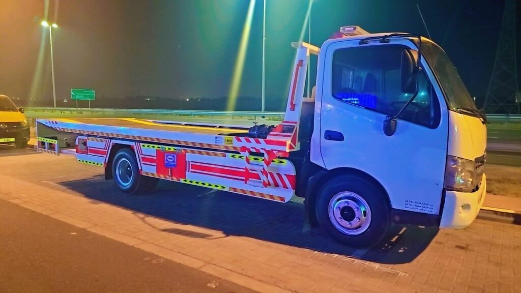Sentinal Recovery flatbed truck with work lights on, ready for a night call-out