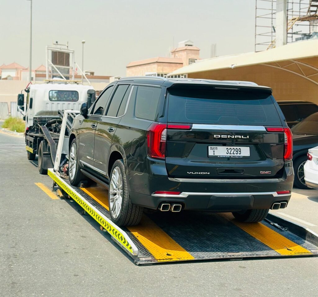 Black GMC Yukon Denali being loaded onto a flatbed ramp