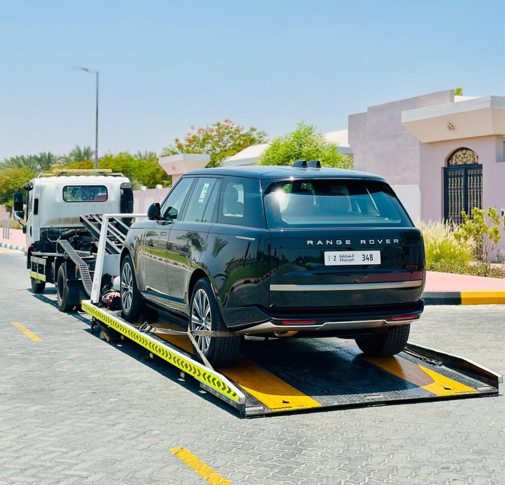 Black Range Rover being loaded up a tilted flatbed ramp