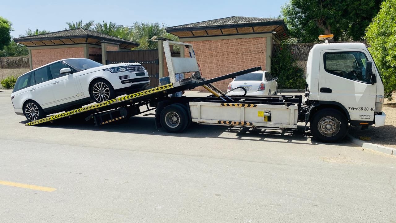White Range Rover rolling onto a tilt-bed recovery truck