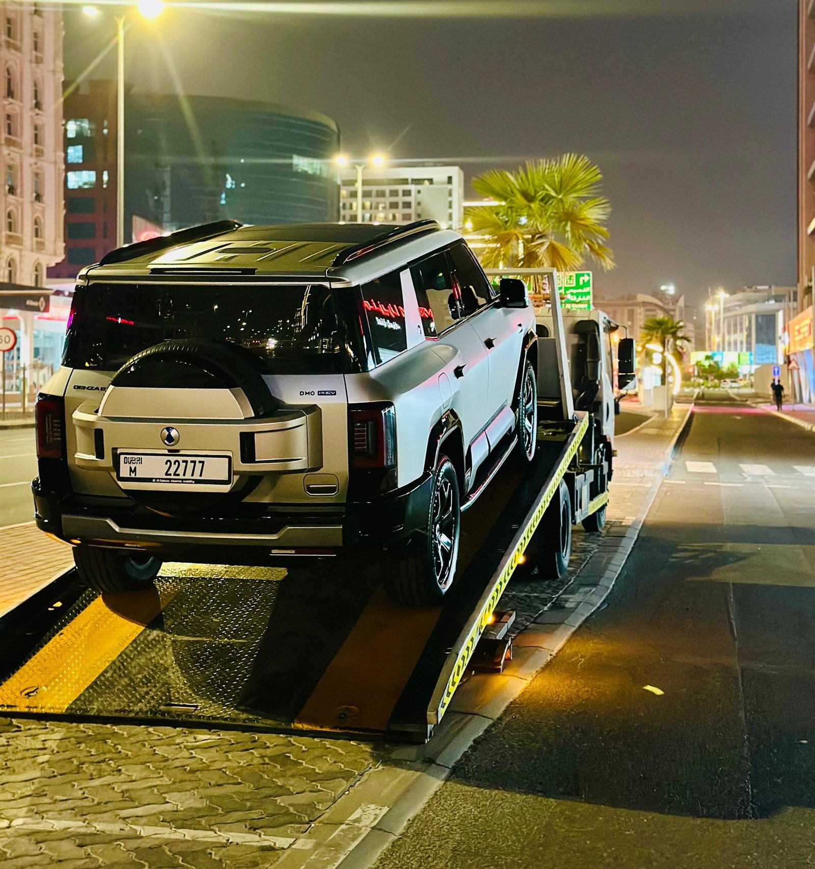 Luxury SUV loaded onto a flatbed during a night-time recovery in Dubai
